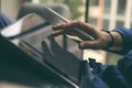 Close up view of businessman hand using stylus pen for touching the digital tablet screen. Blurred background