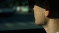 Close up view of businessman looking away while sitting on the back seat of a car. Stock. Business trip and people