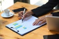 Businesswoman holding pen and checking financial reports on office desk. Royalty Free Stock Photo