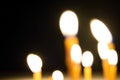 Close up view of the candles burning brightly in the dark. Royalty Free Stock Photo