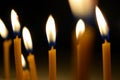 Close up view of the candles burning brightly in the dark. Royalty Free Stock Photo
