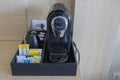 Close up view of capsule coffee machine with accessories on table in hotel room. Royalty Free Stock Photo