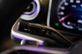 Close-up view of a car indicator control lever with a blurred dashboard in the background