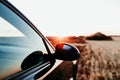 close up view of a car and rear mirror at sunset on a field. Travel concept Royalty Free Stock Photo