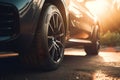 Close-up view of car tire with blurred background and lens flare. Detail of the front mask of the car at sunset. Royalty Free Stock Photo