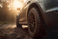 Close-up view of car tire with blurred background and lens flare. Detail of the front mask of the car at sunset. Royalty Free Stock Photo