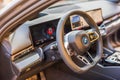 Close-up view of the carbon fiber-trimmed steering wheel and dashboard of the BMW i5-M electric car.