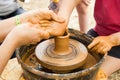 A close up view on ceramic production process on potter`s wheel with children. Clay crafts with kids concept Royalty Free Stock Photo