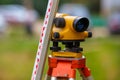 close-up view of cheap geodesy level device with tower ruler outdoors Royalty Free Stock Photo