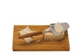 Close up view of cheese with cheese knife isolated on wooden board. Royalty Free Stock Photo