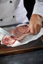 Chef wearing white coat cutting lamb chop Royalty Free Stock Photo