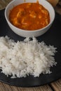 Close-up view of chicken tikka masala curry with rice on black round plate background. Traditional Indian dish with meat and Royalty Free Stock Photo