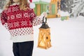 Close up view of child hand holding wood lantern and wearing traditional pattern.