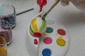 Close up view of child`s hands coloring Easter egg in special utensils. Royalty Free Stock Photo