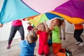 Close up view of children under huge rainbow cover