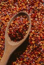 Close up view of chili flakes on wooden spoon. Dried chili flakes as background. Close up view of crushed red cayenne pepper. Royalty Free Stock Photo