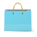 Close-up view of classic blue paper shopping bag with yellow rope grips isolated on white background