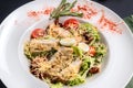 Close-up view on classic Caesar salad with grilled chicken breast and half of quail eggs in white ceramic plate. Green tablecloth Royalty Free Stock Photo