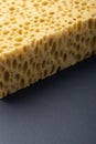 Close up view of cleaning sponge, mesh structure pattern on black surface. Yellow sponge close-up. Royalty Free Stock Photo