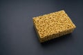 Close up view of cleaning sponge, mesh structure pattern on black surface. Yellow sponge close-up. Royalty Free Stock Photo