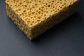 Close up view of cleaning sponge, mesh structure pattern on black surface. Yellow sponge close-up. Royalty Free Stock Photo