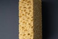 Close up view of cleaning sponge, mesh structure pattern on black surface. Yellow sponge close-up. Royalty Free Stock Photo