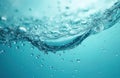 Close-up view of clear blue water surface with small bubbles and droplets. Flowing liquid forms gentle wave motion. Refreshing Royalty Free Stock Photo