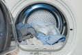 Close up view on clothes dryer with washed and dried shirts in and door open Royalty Free Stock Photo