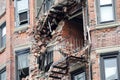 Collapsed brick building facade with damaged fire escape stairs Royalty Free Stock Photo