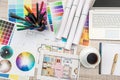 Close up view of color palette swatch and house building plans on office desk with laptop and cup of coffee for break Royalty Free Stock Photo