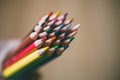 Close up view of color pencils in hand on wooden background. Selective focus. Royalty Free Stock Photo
