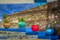 Close up view of colorful pottery with plants on stairway.