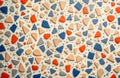 Close-up view of colorful terrazzo surface. Geometric shapes in orange blue beige, grey create abstract pattern. Stylish mosaic