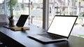 Computer laptop with blank screen on black wooden table in office room. Royalty Free Stock Photo