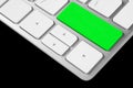 Close up view of a computer notebook keyboard with one green empty button isolated on black background. Technology background empt Royalty Free Stock Photo