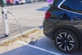 Close up view of connected charging cable to black BMW car from an electric vehicle charging station. Sweden.