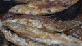 Close-up view of cooking frying capelin fish in iron pan. Grilled caplin fish - popular Asian cuisine