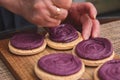 Close up view of Cooking macarons cookies at home. Female hand squeezes cream on homemade cookie Royalty Free Stock Photo