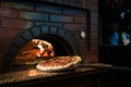 close up view of cooking process of raw pizza on wooden stove Royalty Free Stock Photo