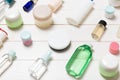 Close-up view of cosmetic bottles, jars, containers and sprays on white wooden background. Beauty concept with copy space