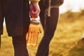 Close up view of couple that walking outdoors. Man holds bottle with water