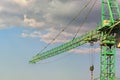 Close-up view of crane against blue sky during sunset. Green tower crane building the new residential building. Royalty Free Stock Photo