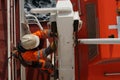 Close up view on crew member with orange jacket and white helmet