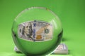 Close up view of crystal ball with 100 dollar bill isolated on green background. Royalty Free Stock Photo