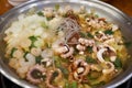 Close-up view of cuisine with various sea food ingredients such as shrimp, small octopus, and tripe