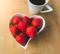 Cup of coffee and fresh strawberries on wooden table Royalty Free Stock Photo