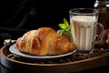 Close-up view of a cup of coffee latte with croissant in dark background.