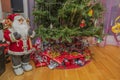 Close-up view of cute Santa Claus figure and wrapped presents under Christmas tree.