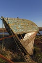 Close Up view of the damaged bow of a small inshore wooden Fishing Boat next to a small estuary