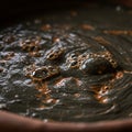 A close-up view of a dark liquid mixture with thick, viscous texture, resembling mud o Royalty Free Stock Photo